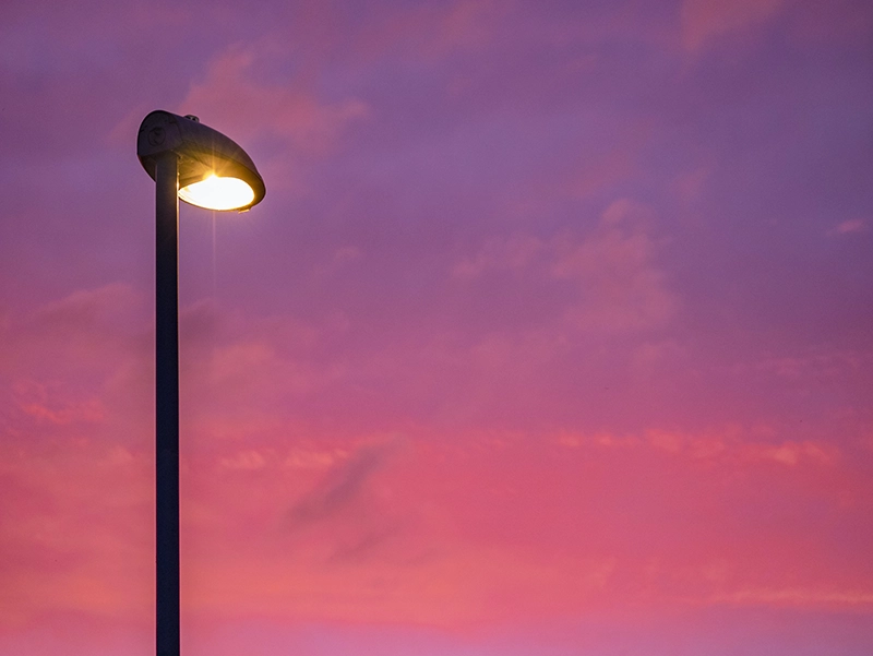 Street light - a frangible structure - against a pink and purple sunset