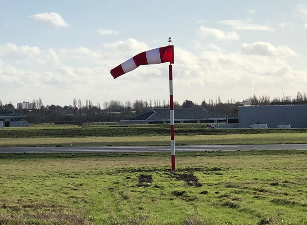 Red and white windsock and frangible mast at RAF Northolt airfield